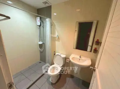 Modern bathroom with shower, toilet, and sink in a compact layout.