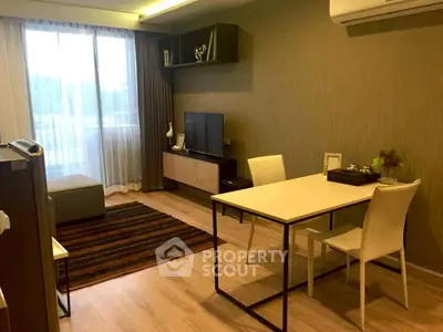 Modern living room with stylish decor and natural light, featuring a cozy seating area and dining table.