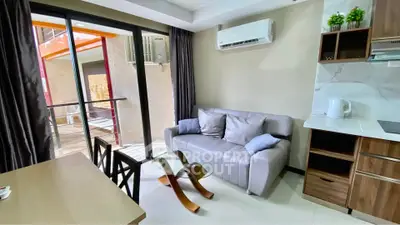 Modern living room with sleek furniture and air conditioning, featuring a cozy sofa and stylish decor.
