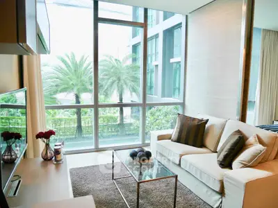 Luxurious living room with floor-to-ceiling windows and lush garden view.