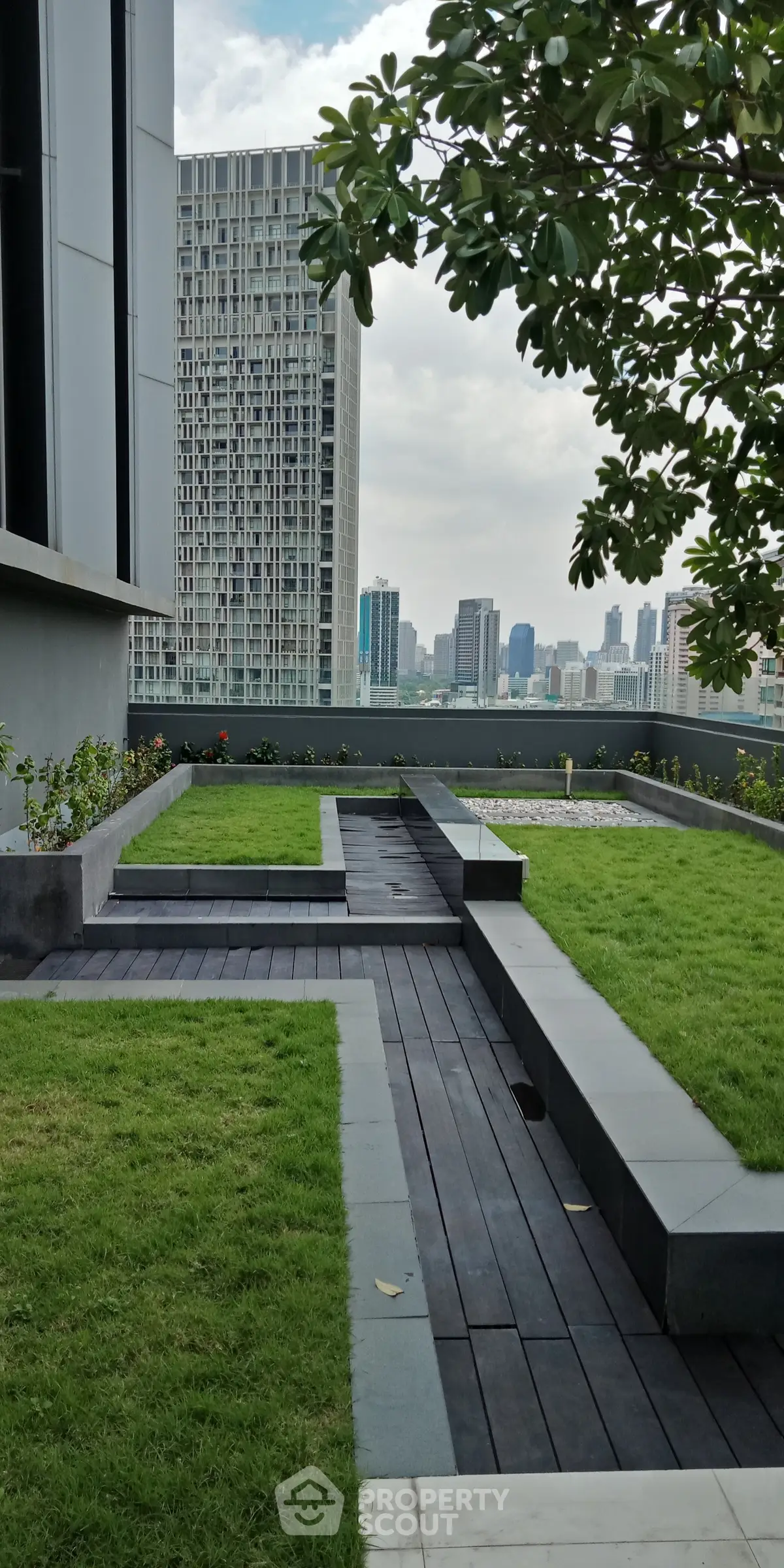 Modern rooftop garden with city skyline view, featuring sleek design and lush greenery.