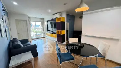 Modern living room with stylish furniture and city view, featuring a cozy sofa and dining area.