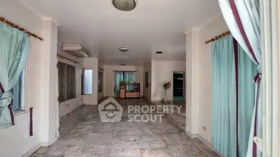 Spacious living room with tiled floors and large windows, perfect for natural light.