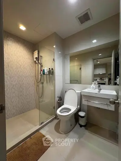 Modern bathroom with glass shower, sleek fixtures, and elegant tiling in a contemporary home.