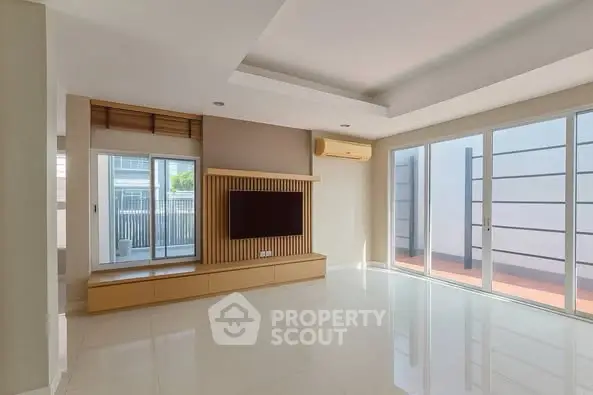 Spacious modern living room with large windows and built-in TV unit