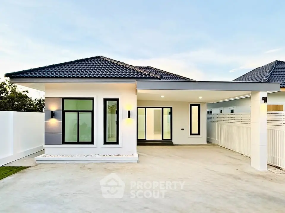 Modern single-story house with sleek design and spacious driveway.
