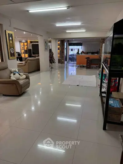 Spacious open-plan living area with modern furnishings and glossy tiled floors.