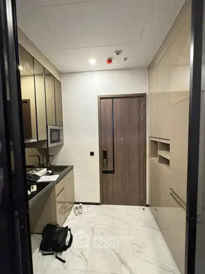Modern kitchen with sleek cabinetry and built-in microwave in a compact layout.