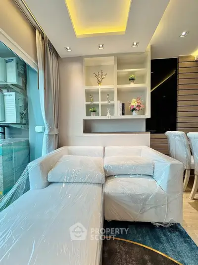 Modern living room with elegant white sofa and stylish shelving, perfect for contemporary urban living.