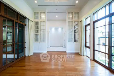 Spacious and elegant living room with large windows and wooden flooring