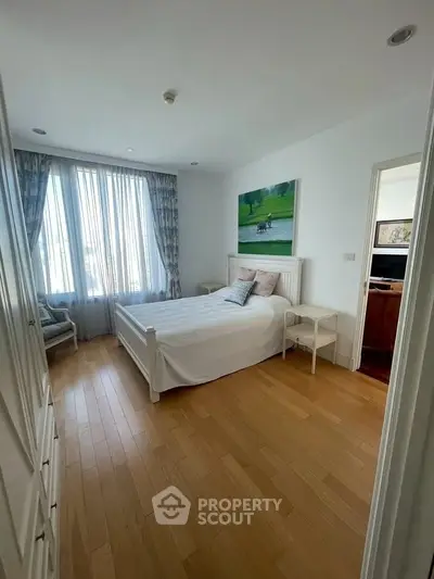 Bright and cozy bedroom with wooden flooring and large window