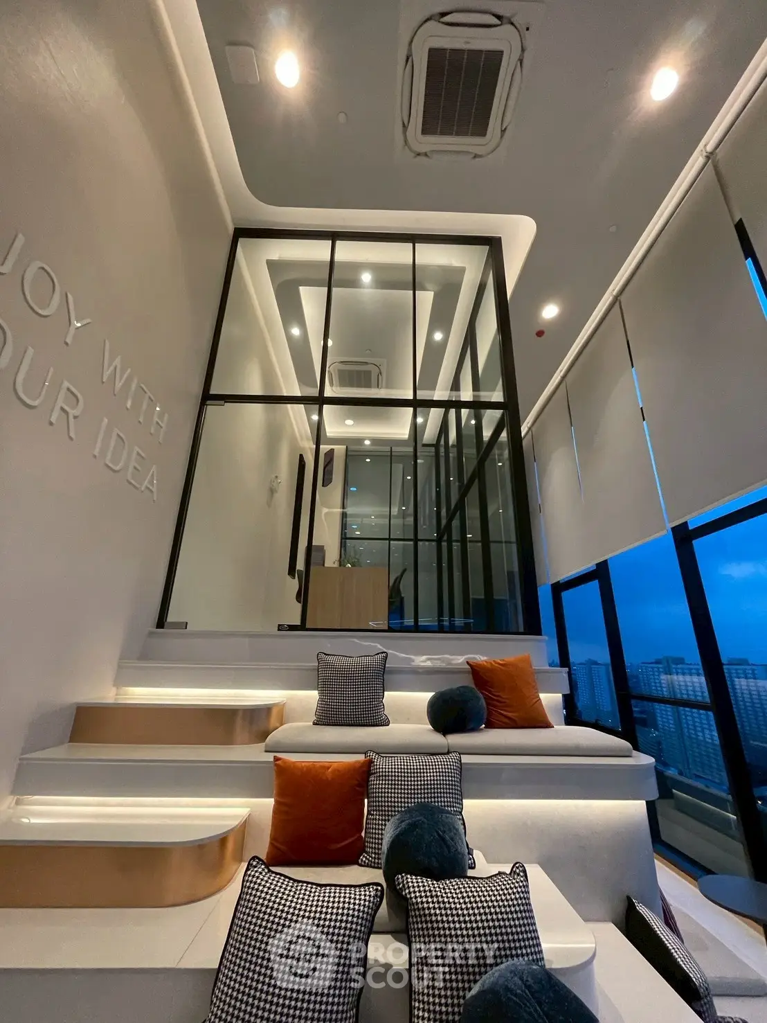 Modern interior with stylish seating and large windows offering city views.