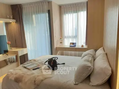 Luxurious bedroom with modern decor and ample natural light, featuring elegant furnishings and a cozy ambiance.