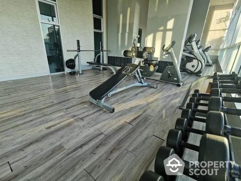 Modern gym with state-of-the-art fitness equipment and large windows for natural light.