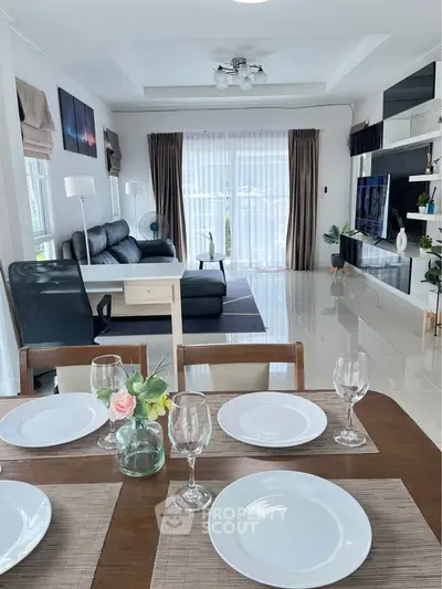 Spacious modern living room with elegant dining area and large windows.