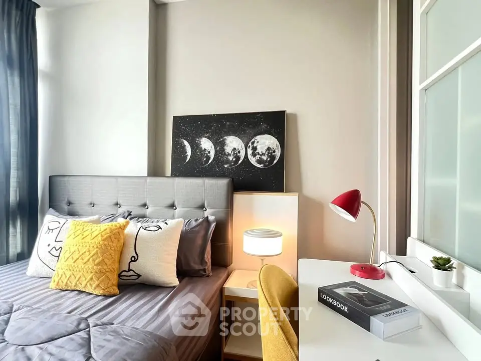 Modern bedroom with stylish decor, featuring a cozy bed, chic artwork, and a functional study desk.