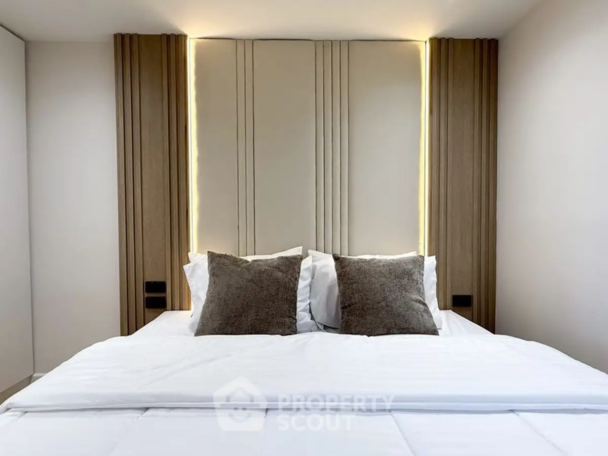 Luxurious modern bedroom with elegant lighting and plush pillows.