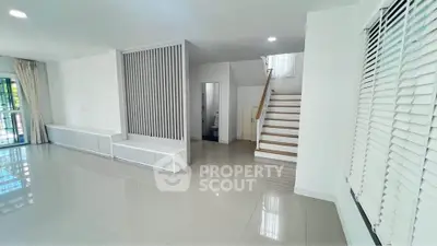 Spacious modern living room with sleek staircase and large windows