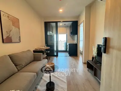 Modern living room with cozy sofa and open kitchen layout in stylish apartment.