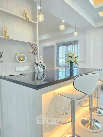 Modern kitchen with stylish bar counter and elegant lighting in a contemporary home.