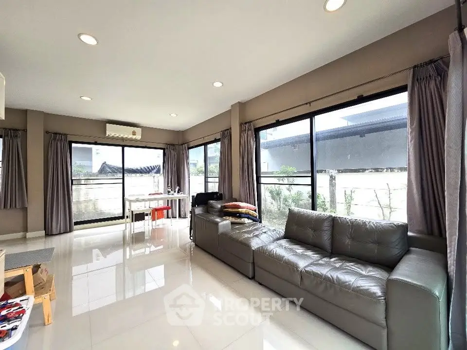 Spacious modern living room with large windows and sleek furniture