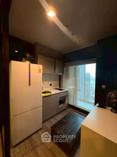 Modern kitchen with sleek appliances and balcony view in urban apartment