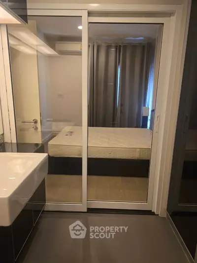 Modern bedroom with glass sliding doors and sleek bathroom sink