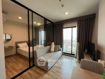 Modern studio apartment with glass partition, cozy living area, and balcony view.