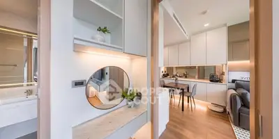 Modern open-plan apartment with stylish kitchen and cozy living area, featuring sleek design and natural lighting.