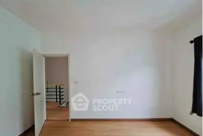 Spacious empty room with wooden flooring and natural light, ideal for customization.