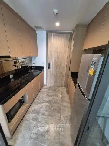 Modern kitchen with sleek cabinetry and stainless steel appliances in a compact layout.