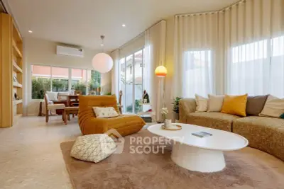 Stylish living room with modern furniture and large windows offering natural light.