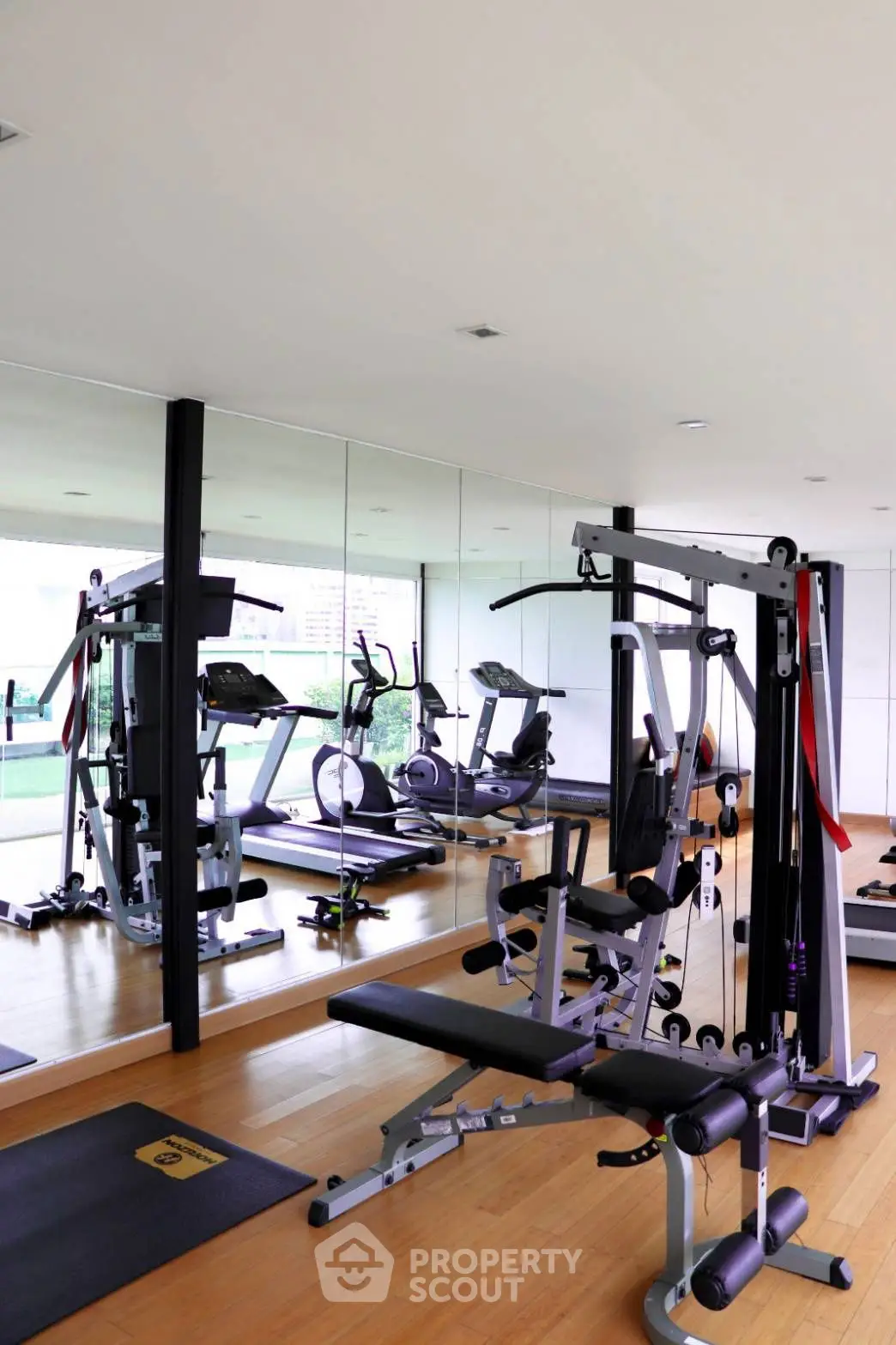 Modern gym with state-of-the-art equipment and mirrored walls in luxury real estate property.