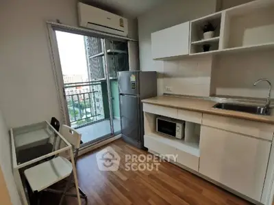 Modern kitchen with balcony view, featuring sleek cabinetry and appliances in a compact layout.