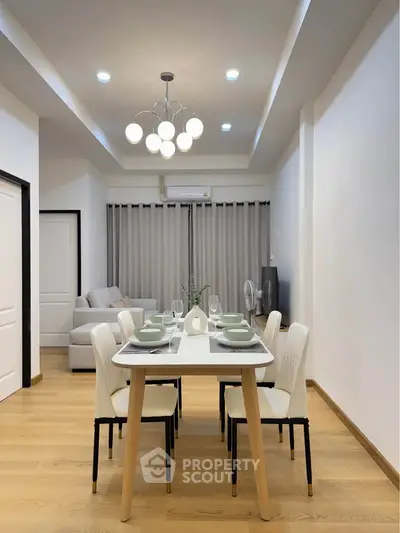 Modern dining area with elegant table setting and cozy living room in open layout apartment.