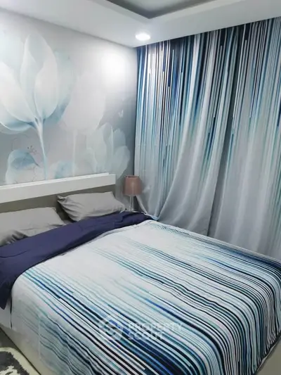 Modern bedroom with stylish blue striped bedding and artistic wall design