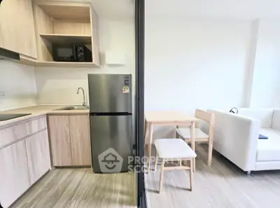 Modern open-layout kitchen and living area with sleek appliances and cozy dining space.