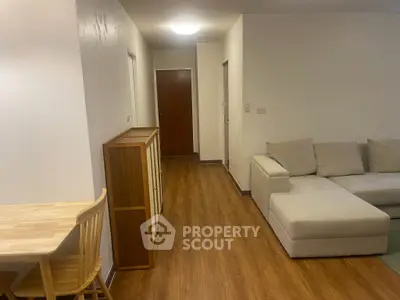 Spacious living room with modern furniture and wooden flooring in a cozy apartment.