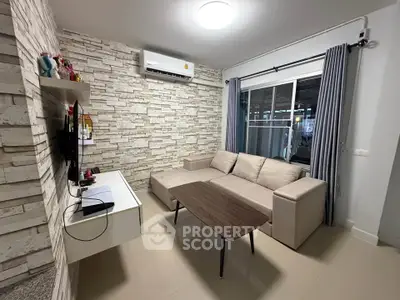 Modern living room with stylish stone accent wall and cozy beige sectional sofa.