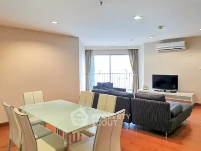 Spacious modern living room with dining area and balcony view, featuring sleek furniture and ample natural light.