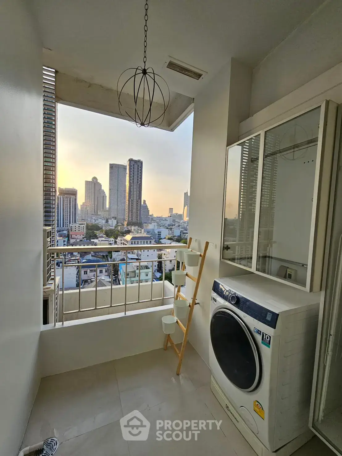 Modern laundry area with city view, featuring a washing machine and stylish decor.