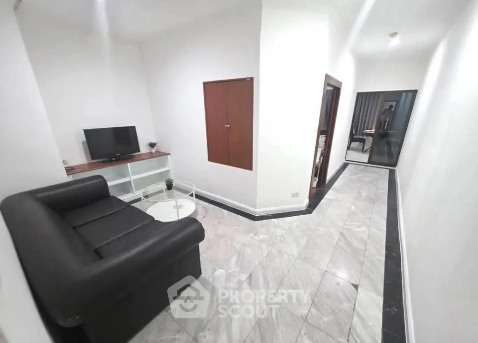 Modern living room with sleek black sofa and marble flooring