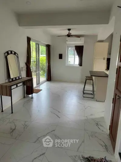 Spacious living area with modern marble flooring and natural light
