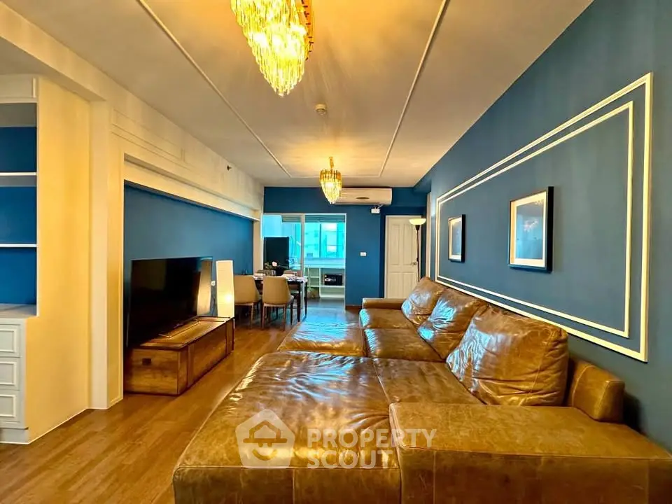 Spacious living room with elegant blue walls and luxurious leather sofa