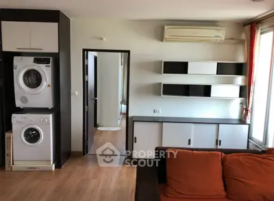 Modern living room with built-in washer and dryer, air conditioning, and stylish shelving.