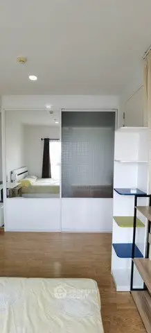Modern bedroom with wooden flooring and stylish shelving unit