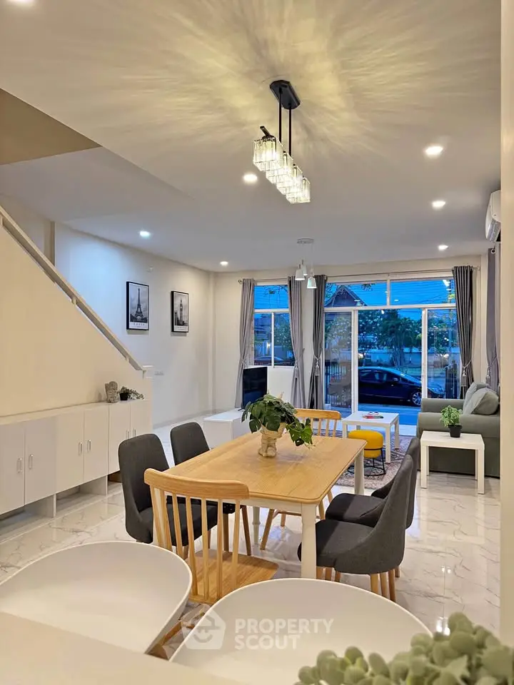 Spacious modern living room with elegant dining area and large windows for natural light.