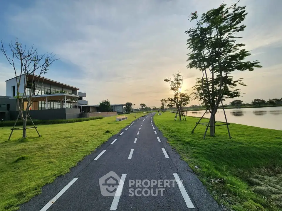 Modern lakeside property with scenic pathway and lush greenery