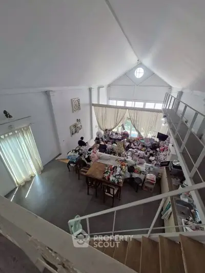 Spacious loft-style living room with high ceilings and abundant natural light.