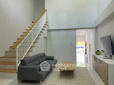 Modern living room with high ceiling and stylish staircase